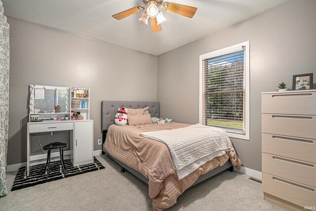 bedroom featuring visible vents, baseboards, carpet, and a ceiling fan