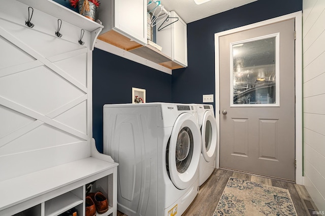 washroom with wood finished floors, cabinet space, and washer and clothes dryer