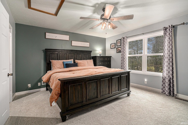 bedroom with visible vents, baseboards, ceiling fan, light colored carpet, and attic access