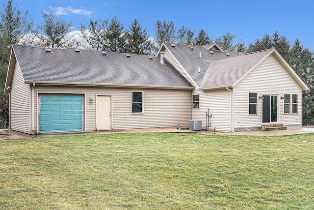 rear view of house featuring central AC unit, a lawn, entry steps, and a shingled roof