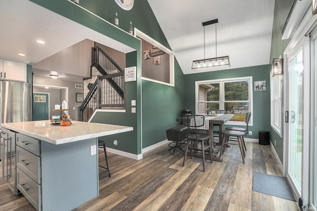 kitchen with vaulted ceiling, wood finished floors, baseboards, and a wealth of natural light