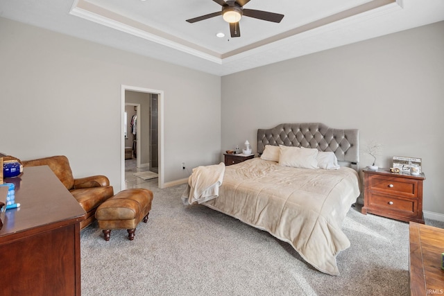 bedroom featuring a tray ceiling, baseboards, carpet, and a ceiling fan