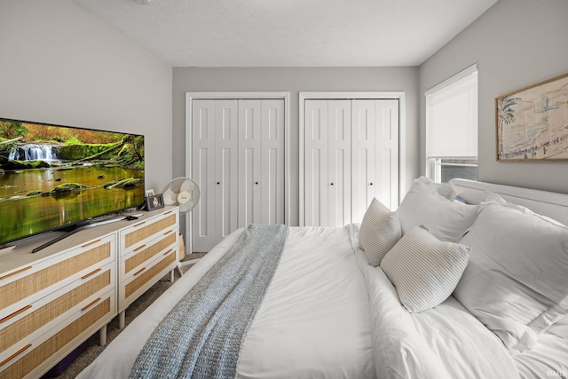 bedroom with cooling unit and multiple closets