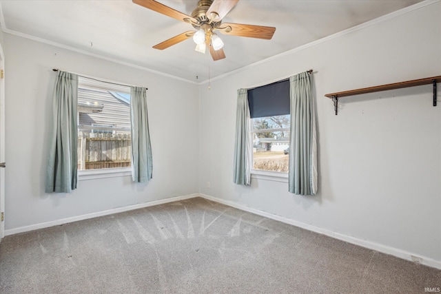 spare room with crown molding, baseboards, and carpet floors