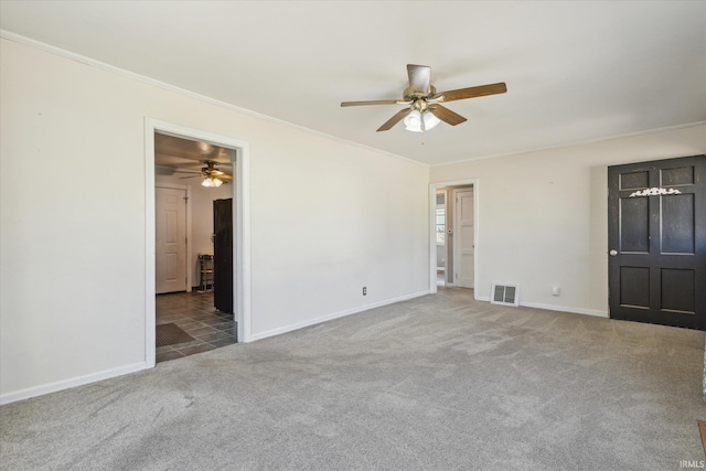 unfurnished bedroom featuring visible vents, baseboards, carpet flooring, and crown molding