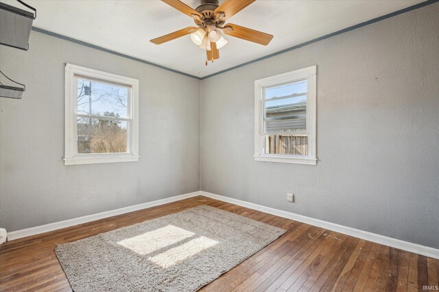 empty room featuring hardwood / wood-style floors, baseboards, and a wealth of natural light