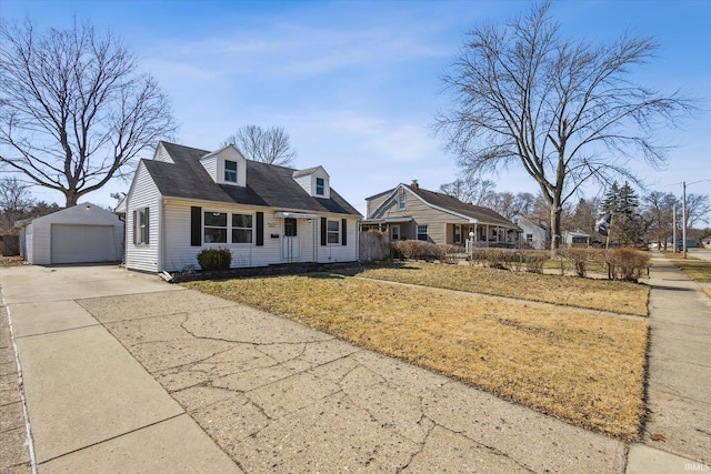 new england style home featuring a garage, driveway, an outdoor structure, and a front yard