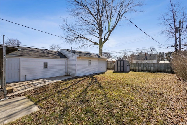 view of yard featuring an outbuilding, a patio area, a storage shed, and fence