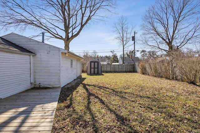 view of yard with an outbuilding, a shed, and fence