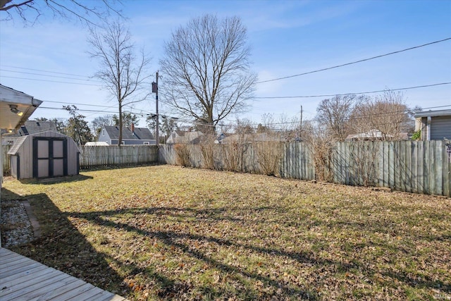 view of yard featuring an outbuilding, a fenced backyard, and a shed