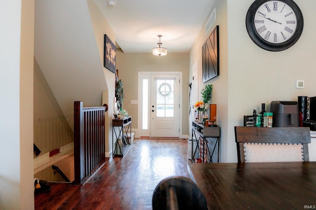 foyer featuring visible vents, baseboards, and wood finished floors