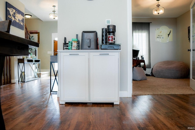 kitchen featuring dark wood-style floors, hanging light fixtures, and white cabinetry