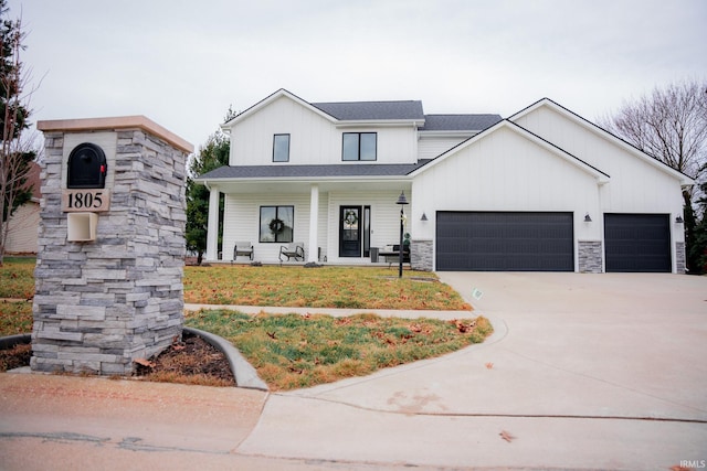 modern farmhouse style home with a front yard, driveway, a porch, a garage, and stone siding