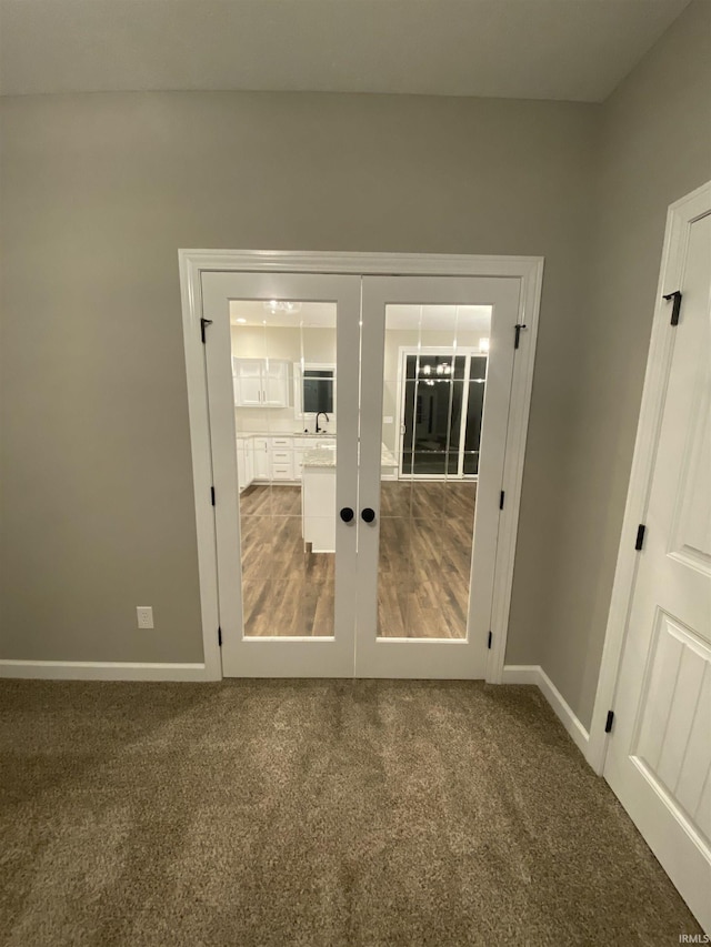 doorway with french doors, baseboards, and carpet flooring