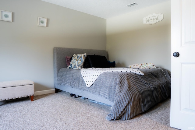 carpeted bedroom featuring baseboards and visible vents