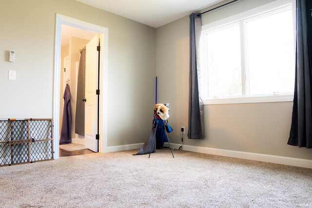 spare room featuring baseboards and carpet floors