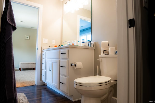 bathroom with toilet, wood finished floors, and vanity