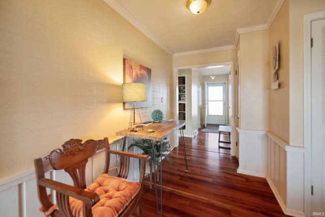 hallway with a wainscoted wall, a decorative wall, wood finished floors, and ornamental molding