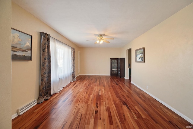 unfurnished living room with visible vents, wood-type flooring, baseboards, and ceiling fan