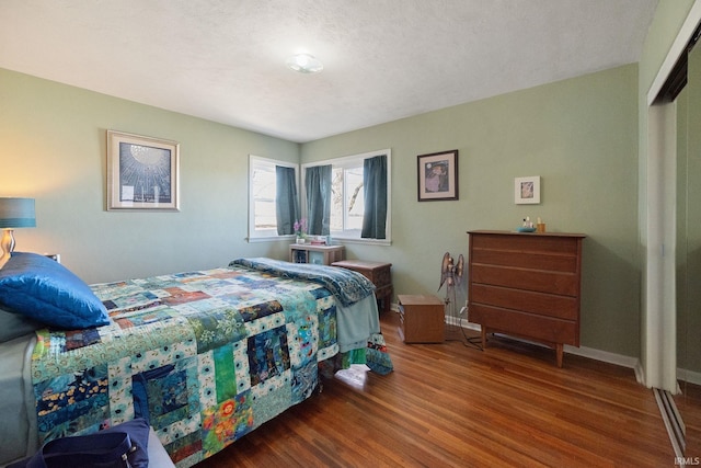 bedroom with baseboards and wood finished floors