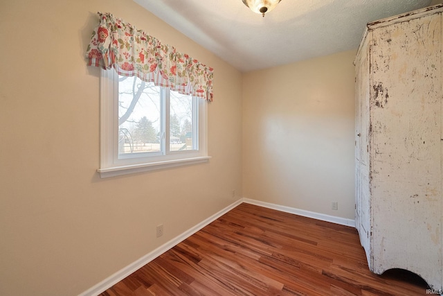 empty room with baseboards and wood finished floors