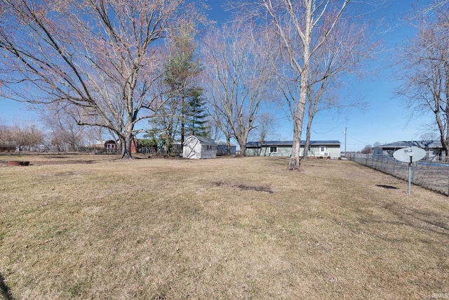 view of yard with an outbuilding, a storage shed, and fence