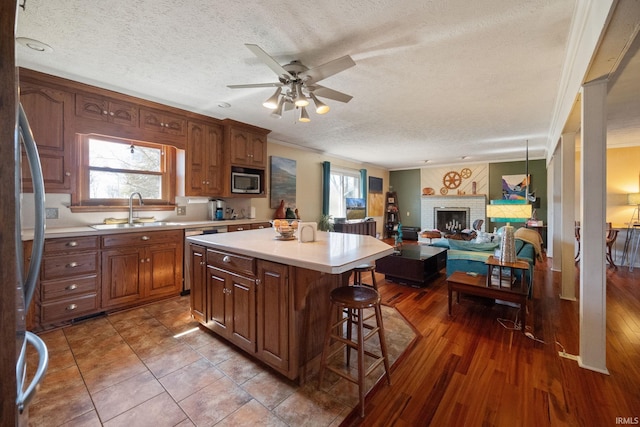 kitchen with a wealth of natural light, a breakfast bar, a sink, appliances with stainless steel finishes, and light countertops