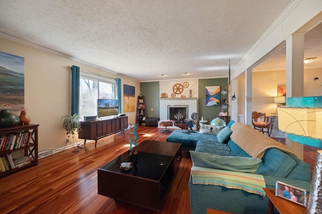 living area with wood finished floors, a fireplace, and ornamental molding