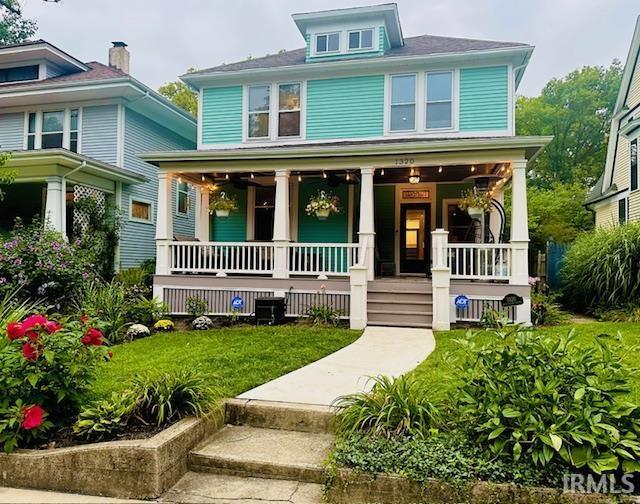 traditional style home featuring a front yard and covered porch