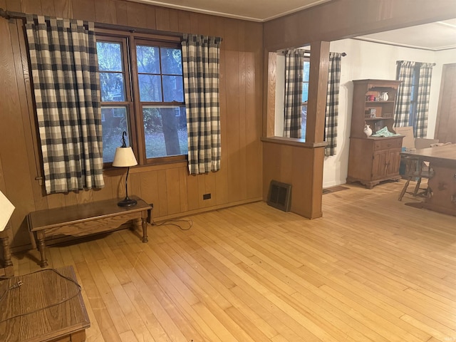 sitting room with visible vents, wooden walls, and wood-type flooring