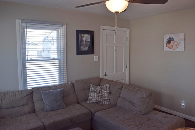 living area with baseboards, a healthy amount of sunlight, and ceiling fan