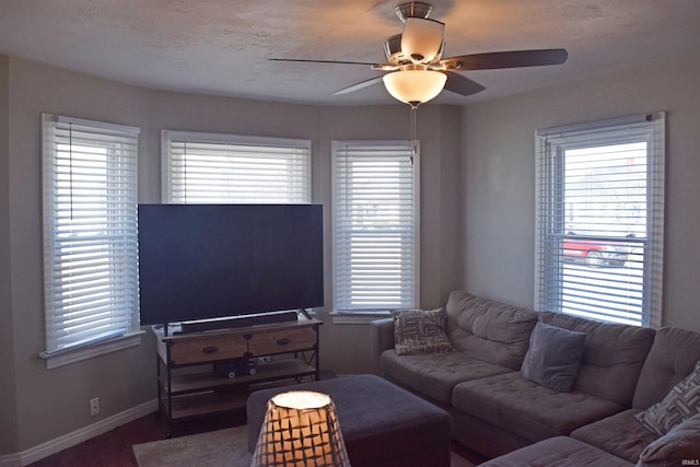 living room featuring a ceiling fan and baseboards