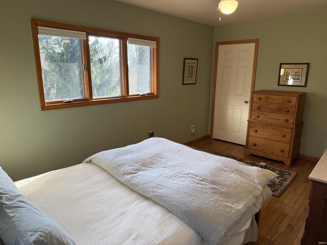 bedroom with dark wood finished floors and baseboards