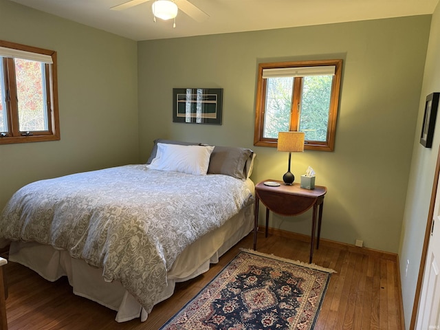 bedroom with ceiling fan, baseboards, and hardwood / wood-style floors