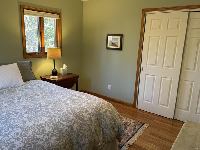 bedroom with a closet, baseboards, and wood finished floors