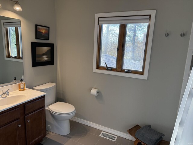 bathroom featuring vanity, toilet, a healthy amount of sunlight, and visible vents