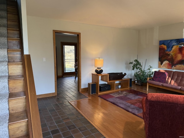 living room featuring stairs, baseboards, and wood finished floors