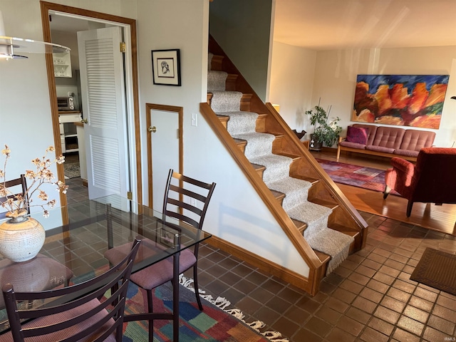 dining space with baseboards and stairs