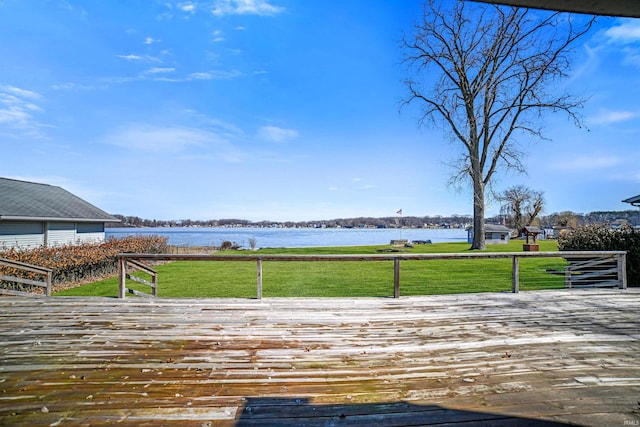 wooden terrace with a yard and a water view