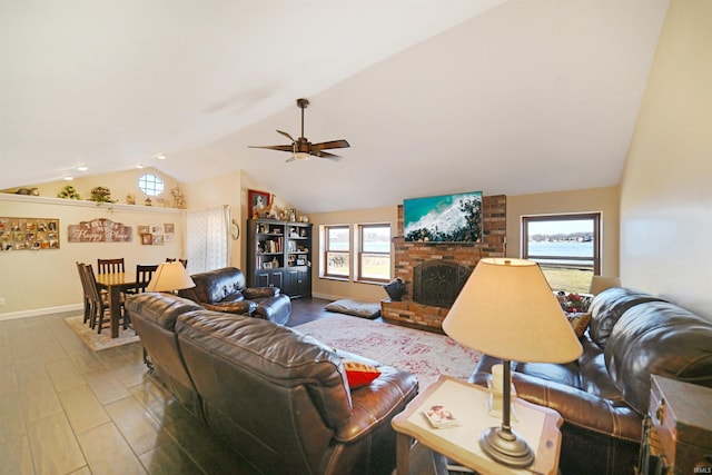 living room featuring ceiling fan, a brick fireplace, baseboards, and vaulted ceiling