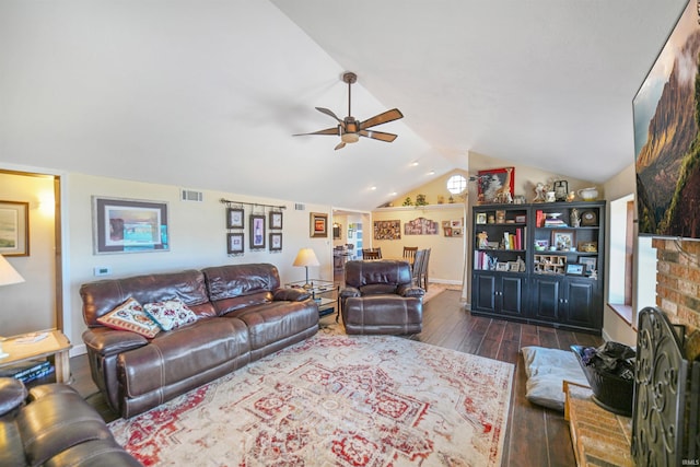 living room with visible vents, dark wood finished floors, a fireplace, ceiling fan, and vaulted ceiling