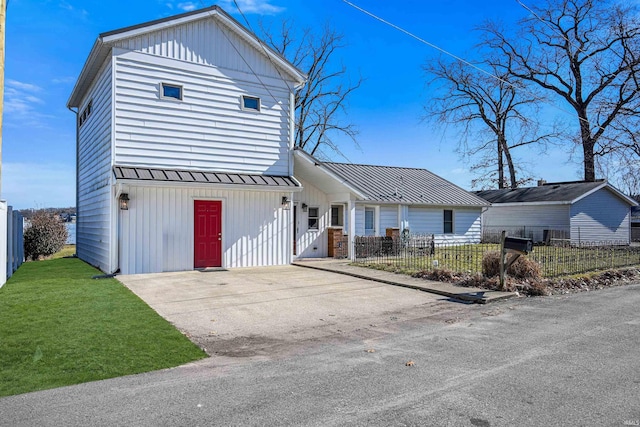 view of front facade with a fenced front yard, board and batten siding, metal roof, and a standing seam roof