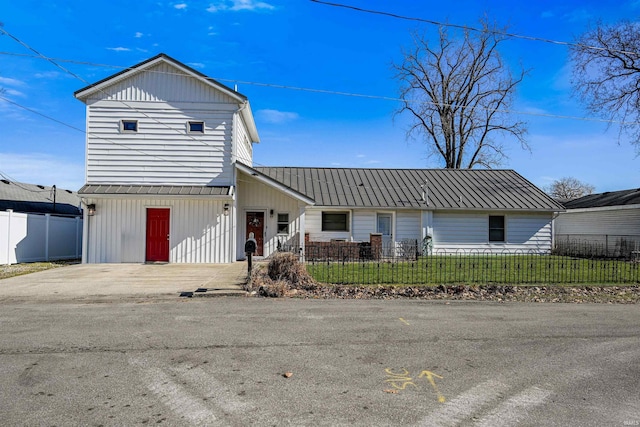 view of front facade with a fenced front yard, metal roof, and a standing seam roof