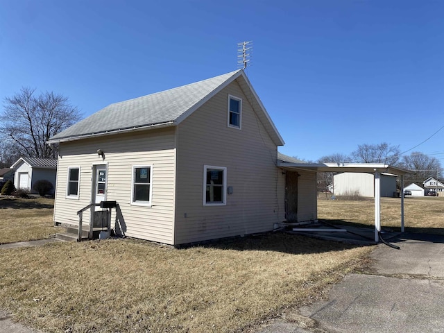 exterior space featuring a lawn and roof with shingles