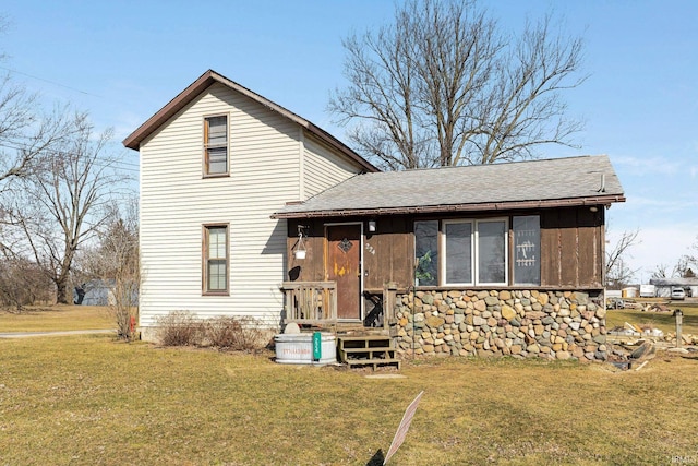 traditional-style home featuring a shingled roof and a front yard