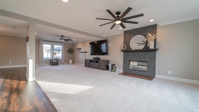 carpeted living room with crown molding, recessed lighting, baseboards, and a large fireplace