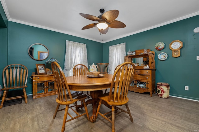 dining area with ceiling fan, baseboards, wood finished floors, and crown molding