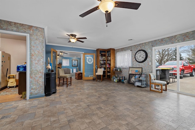 living area featuring stone finish floor, wallpapered walls, baseboards, and ornamental molding