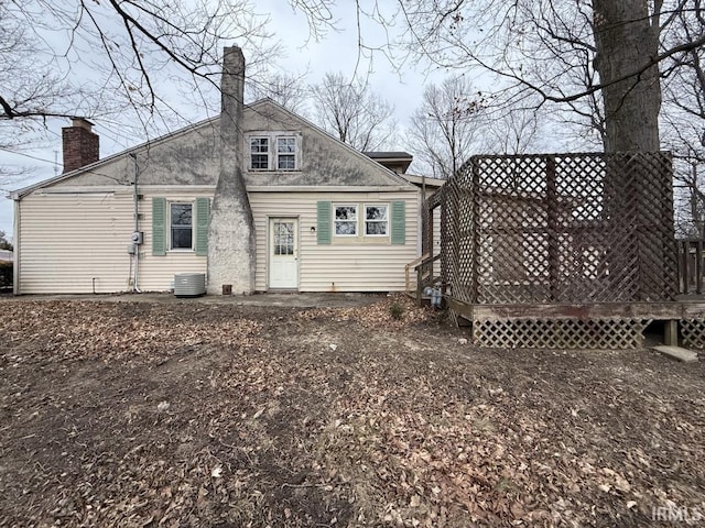 back of property featuring central AC, a deck, and a chimney