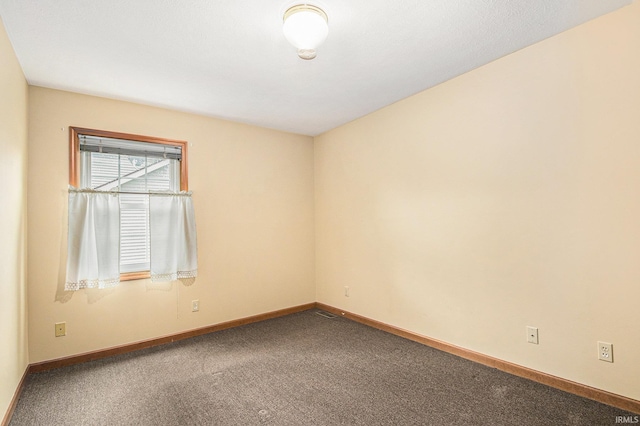 empty room with baseboards and carpet